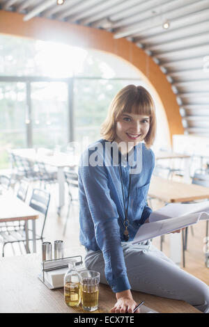 Businesswoman smiling in cafeteria Banque D'Images