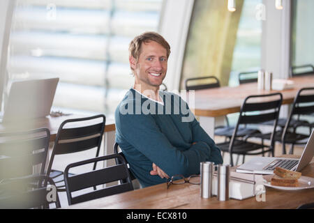 Businessman using laptop in cafeteria Banque D'Images