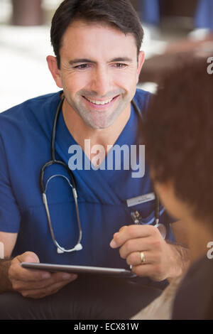 Portrait of mid adult doctor holding tablet pc Banque D'Images