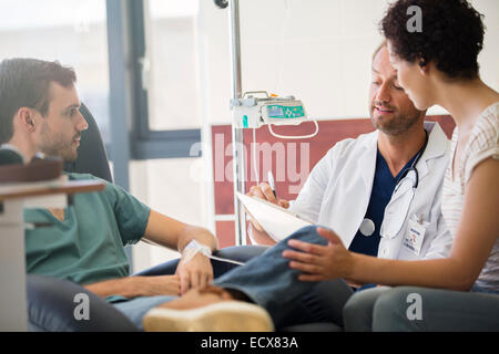 Médecin et patient interrogatoire writing on clipboard Banque D'Images