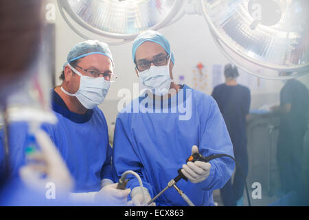 Portrait de médecins pratiquant la chirurgie laparoscopique en salle d'opération Banque D'Images