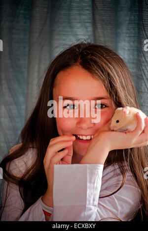 Petite fille posant avec son hamster animaux en Irlande Banque D'Images