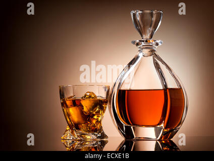 Carafe et verre de whisky d'or sur fond brun Banque D'Images