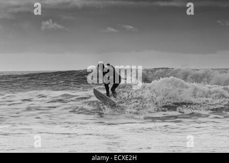 De bonnes conditions en mer permet à un internaute de rouler une bonne vague pour une longue course au nord du Pays de Galles, Porth Neigwl Banque D'Images