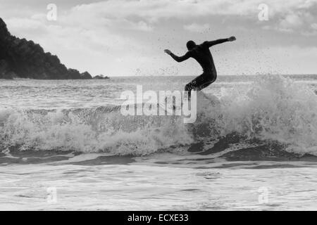 De bonnes conditions en mer permet à un internaute de rouler une bonne vague pour une longue course au nord du Pays de Galles, Porth Neigwl Banque D'Images