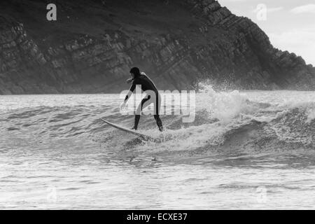 De bonnes conditions en mer permet à un internaute de rouler une bonne vague pour une longue course au nord du Pays de Galles, Porth Neigwl Banque D'Images