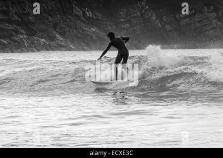 De bonnes conditions en mer permet à un internaute de rouler une bonne vague pour une longue course au nord du Pays de Galles, Porth Neigwl Banque D'Images