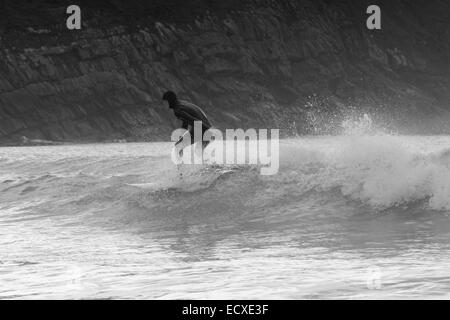 De bonnes conditions en mer permet à un internaute de rouler une bonne vague pour une longue course au nord du Pays de Galles, Porth Neigwl Banque D'Images