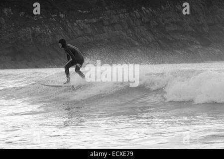 De bonnes conditions en mer permet à un internaute de rouler une bonne vague pour une longue course au nord du Pays de Galles, Porth Neigwl Banque D'Images