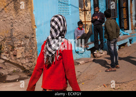 Jeune fille dans un cavalier rouge marcher dans une rue de Jodhpur, Rajasthan, India Banque D'Images