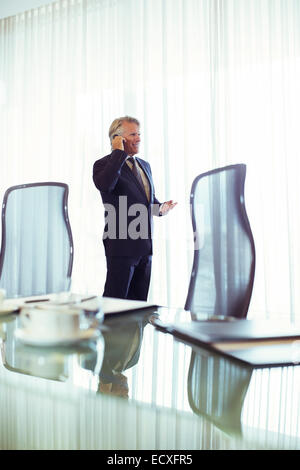 Homme debout dans la salle de conférence à parler sur son téléphone portable Banque D'Images