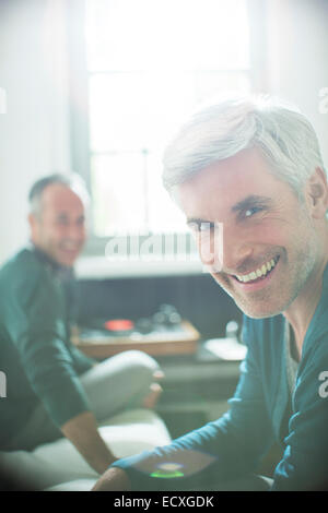 Gay couple relaxing together with record player Banque D'Images