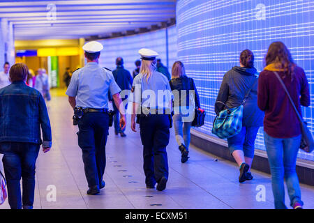 Les passagers dans un passage souterrain avec un mur de lumières, patrouille de police, Banque D'Images