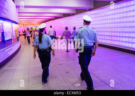 Les passagers dans un passage souterrain avec un mur de lumières, patrouille de police, Banque D'Images