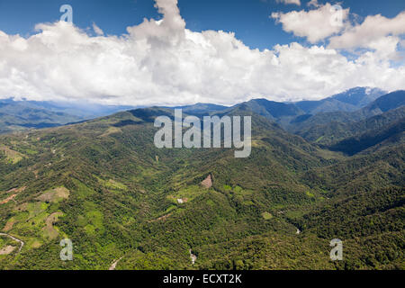 Une perspective aérienne capture une vaste étendue de chaînes de montagnes vallonnées couvertes d'une végétation verte dense. Le terrain présente des collines et des vallées ondulées, avec des taches de vert plus clair suggérant Banque D'Images
