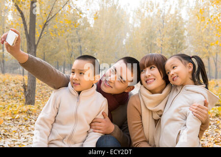 Famille avec deux enfants au parc de prendre des selfies Banque D'Images