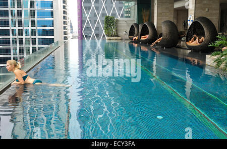 Vue du 14e étage de chaises longues à la piscine, l'Eastin Grand Hotel Sathorn, Bangkok, Thaïlande skyline. Banque D'Images