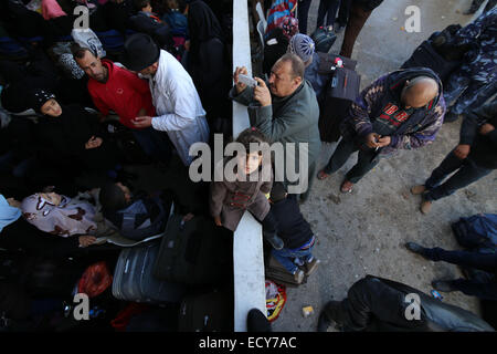 Gaza, l'Egypte avec sa famille. Dec 22, 2014. Une fille palestinienne, dans l'espoir de pénétrer en Egypte avec sa famille, attend au point de passage de Rafah entre l'Egypte et le sud de la bande de Gaza le 22 décembre, 2014. L'Egypte a rouvert temporairement le poste frontalier de Rafah le dimanche autorisant les Palestiniens de la bande de Gaza d'entrer et sortir pour la première fois depuis qu'il a été fermé le 25 octobre. Passage de Rafah Egypte fermée à la suite d'une série d'attaques meurtrières menées par des militants islamistes radicaux dans le Sinaï. Credit : Khaled Omar/Xinhua/Alamy Live News Banque D'Images