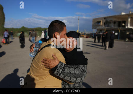 Gaza, l'Egypte. Dec 22, 2014. Un Palestinien, dans l'espoir de pénétrer en Egypte, épouse sa mère au point de passage de Rafah entre l'Egypte et le sud de la bande de Gaza le 22 décembre 2014. L'Egypte a rouvert temporairement le poste frontalier de Rafah le dimanche autorisant les Palestiniens de la bande de Gaza d'entrer et sortir pour la première fois depuis qu'il a été fermé le 25 octobre. Passage de Rafah Egypte fermée à la suite d'une série d'attaques meurtrières menées par des militants islamistes radicaux dans le Sinaï. Credit : Khaled Omar/Xinhua/Alamy Live News Banque D'Images