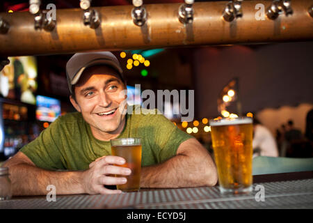 Young man drinking beer en bar Banque D'Images