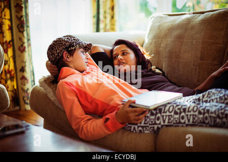 Mère et fille relaxing on sofa Banque D'Images