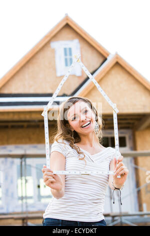 Caucasian woman holding frame près de la maison en construction Banque D'Images