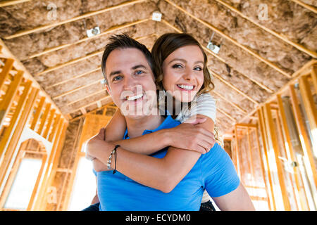 Caucasian couple hugging in house under construction Banque D'Images