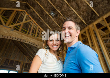 Caucasian couple hugging in house under construction Banque D'Images