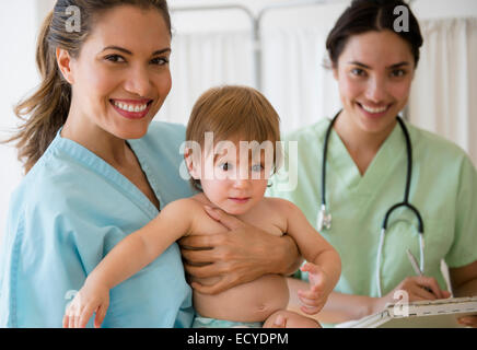Médecin pédiatre et nurse holding baby girl in hospital