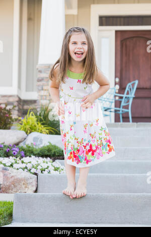 Laughing Caucasian Girl standing on/stoop Banque D'Images