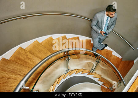 High angle view of Middle Eastern businessman standing on spiral staircase Banque D'Images