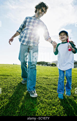 Père et fille walking in grassy field Banque D'Images