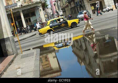 La HAVANE, CUBA - 13 juin, 2011 : old fashioned taxi Lada noire et jaune passe les piétons dans une rue dans le centre de La Havane. Banque D'Images