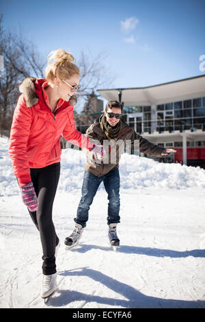 Caucasian couple patinage sur lac gelé Banque D'Images