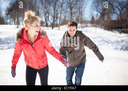 Caucasian couple patinage sur lac gelé Banque D'Images