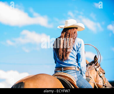 Caucasian girl riding horse in rodeo en plein air Banque D'Images