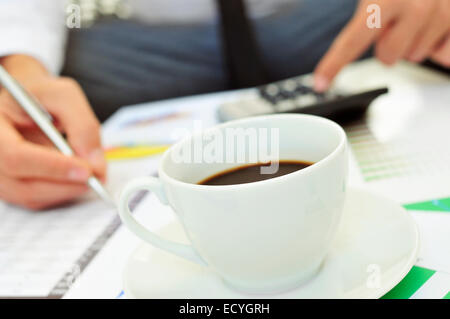 Libre d'un jeune homme avec vérification des comptes d'une calculatrice Banque D'Images