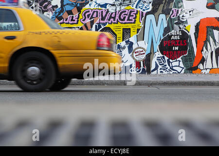 Un jaune New York City taxi est passé le Bowery lecteurs paroi murale sur le Bowery et Houston street NYC Banque D'Images