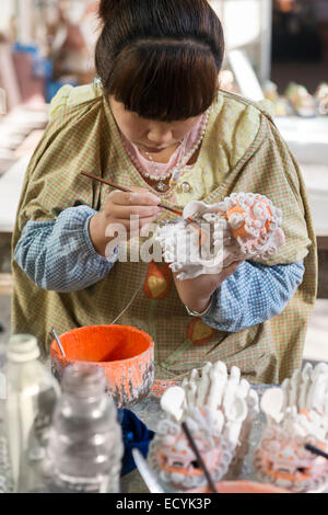 Femme à Terre Cuite peinture en usine d'une sculpture d'un bébé dragon dans Xi'an, Chine Banque D'Images