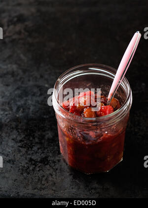 Relish de canneberges Poires pour Noël en pot sur fond sombre, copy space Banque D'Images