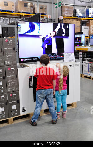 Les enfants qui regardaient la télévision dans un magasin Costco Wholesale, Hayes Rd, Hounslow, Greater London, Angleterre, Royaume-Uni Banque D'Images