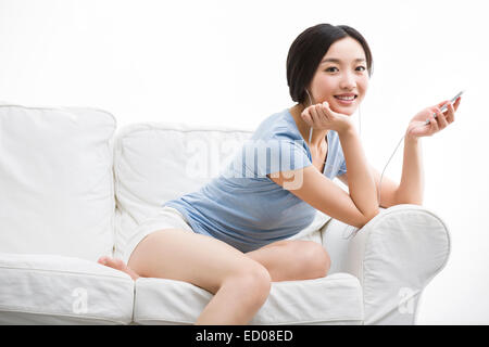 Young woman listening to music on smart phone Banque D'Images
