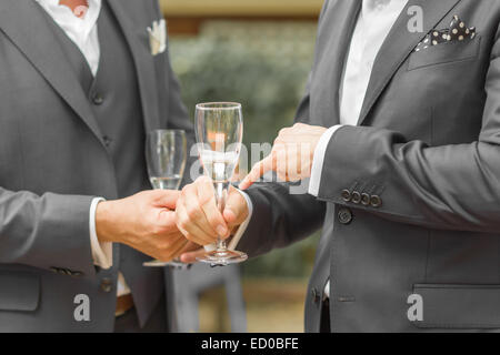 Section intermédiaire de combinaison complète hommes tenant des verres à vin Banque D'Images