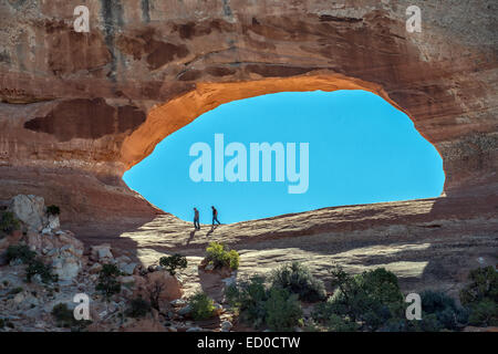 Deux touristes explorer Wilson Arch au sud de Moab et Parc National Arches dans l'Utah. Banque D'Images