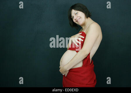 Femme enceinte enveloppé dans du tissu rouge Banque D'Images