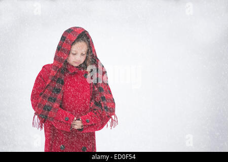 Girl (8-9) en manteau rouge dans la neige Banque D'Images