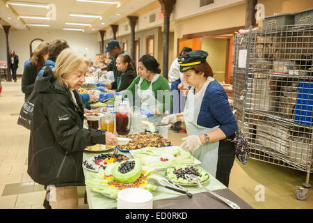 Bénévoles servent le déjeuner sur le côté ouest de la campagne contre la faim (WSCAH) un supermarché style alimentaire garde-manger sur le quartier de l'Upper West Side de New York, le vendredi 19 décembre 2014. Les clients obtiennent de choisir leurs provisions pour eux-mêmes et leurs familles. En 2014 WSCAH ont donné matière à plus de 1,1 millions de repas pour près de 10 000 familles. La distribution de style supermarché favorise l'autonomie et responsabilise les clients. (© Richard B. Levine) Banque D'Images