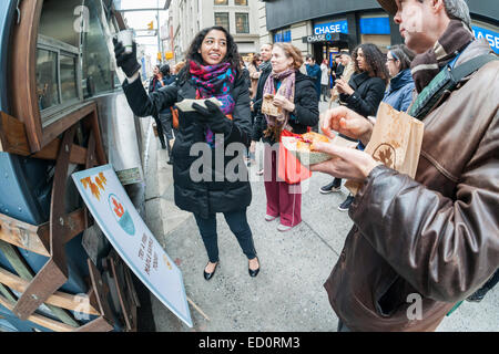 Des hordes d'amateurs queue à la Snowday chariot à New York le Mercredi, Décembre 17, 2014 pour célébrer la Journée nationale du sirop, le partenariat avec le sirop d'érable canadien, avec des échantillons gratuits de nombreux plats, y compris le sirop d'érable et au fromage de porc fumé-curseurs. Le camion alimentaire conscient socialement, partie de conduire le changement, exécute un programme utilisant l'anciennement incarcérées. (© Richard B. Levine) Banque D'Images