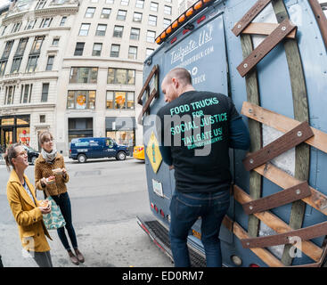 Des hordes d'amateurs queue à la Snowday chariot à New York le Mercredi, Décembre 17, 2014 pour célébrer la Journée nationale du sirop, le partenariat avec le sirop d'érable canadien, avec des échantillons gratuits de nombreux plats, y compris le sirop d'érable et au fromage de porc fumé-curseurs. Le camion alimentaire conscient socialement, partie de conduire le changement, exécute un programme utilisant l'anciennement incarcérées. (© Richard B. Levine) Banque D'Images