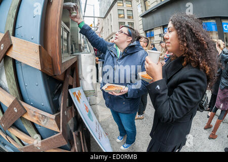 Des hordes d'amateurs queue à la Snowday chariot à New York le Mercredi, Décembre 17, 2014 pour célébrer la Journée nationale du sirop, le partenariat avec le sirop d'érable canadien, avec des échantillons gratuits de nombreux plats, y compris le sirop d'érable et au fromage de porc fumé-curseurs. Le camion alimentaire conscient socialement, partie de conduire le changement, exécute un programme utilisant l'anciennement incarcérées. (© Richard B. Levine) Banque D'Images